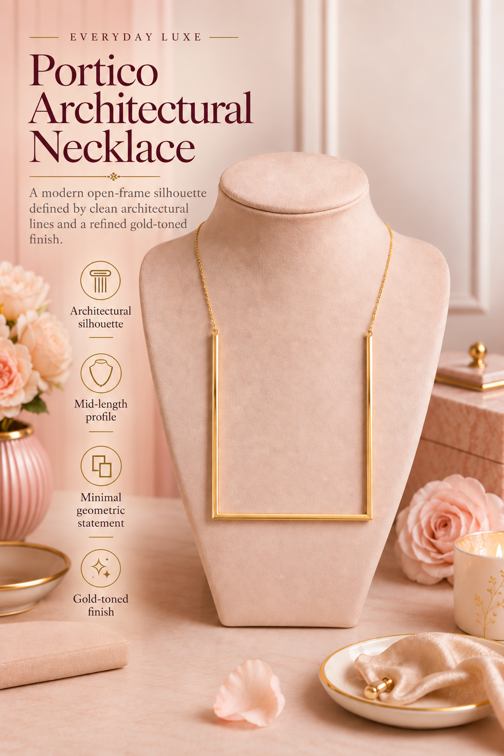 A gold-toned Portico Architectural Necklace displayed on a blush pink jewelry bust, surrounded by soft pink roses, a candle, and decorative boxes in a warm beige setting. The left side includes descriptive text and feature icons for the necklace.